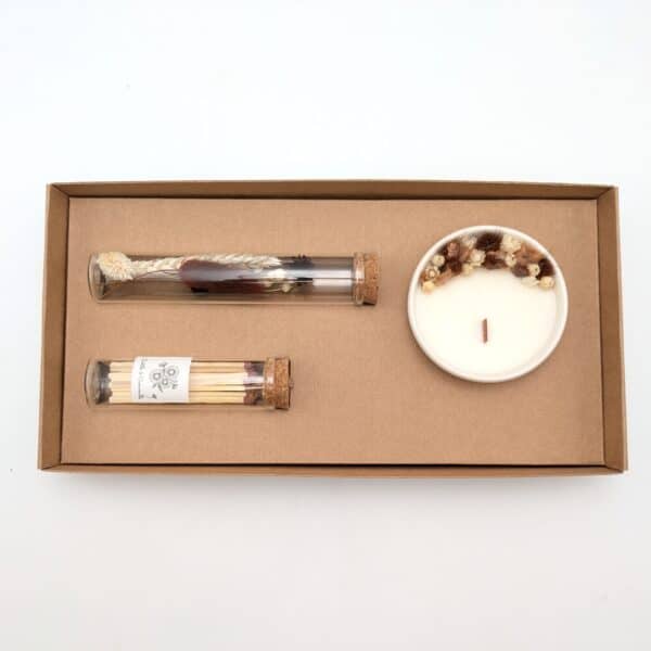 Le coffret prélude contient, une petite bougie fleurs séchées, une fiole de fleurs séchées ainsi qu'une boîte d'allumettes.